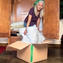 woman placing a blanket into large moving box