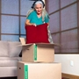 woman packing red pillow into medium moving box