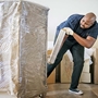 man wrapping furniture with stretch wrap